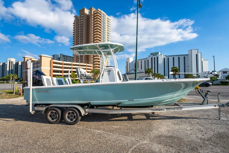 Slide: The Image of 2020 Tidewater 2500 Carolina Bay boat on trailer, urban backdrop, clear sky. - 7