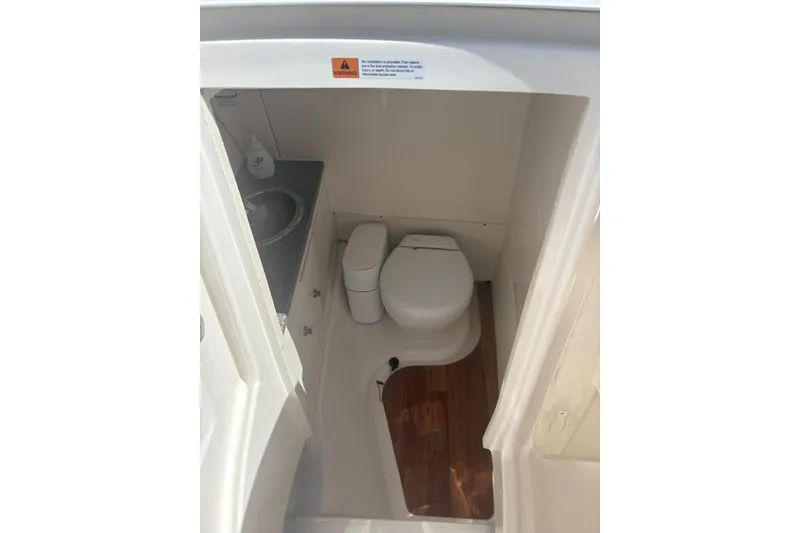 Slide: The Image of 2021 Robalo R317 Dual Console boat bathroom with toilet and sink. - 11