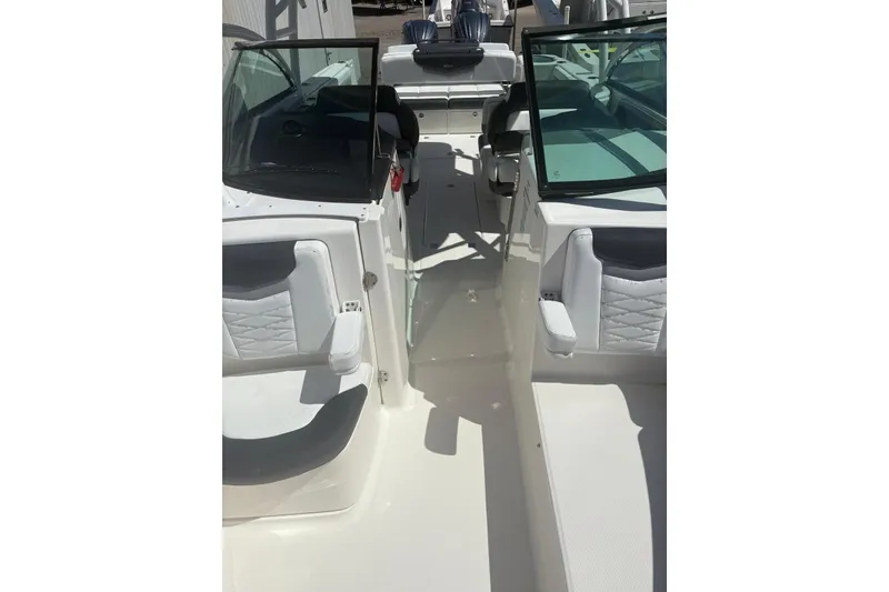 Slide: The Image of 2021 Robalo R317 Dual Console boat interior with white seating and dual windshields. - 16