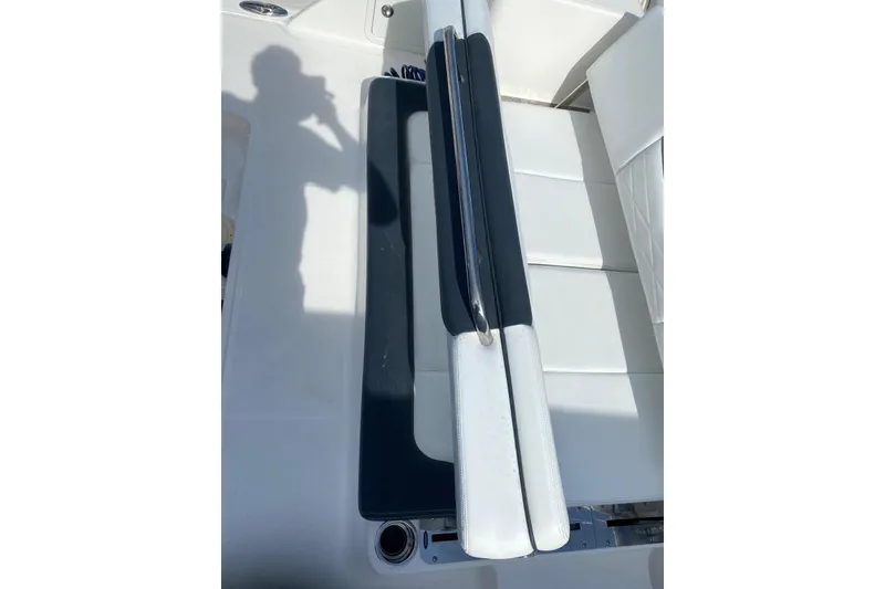 Slide: The Image of 2021 Robalo R317 Dual Console boat seating with shadow and sleek design. - 21