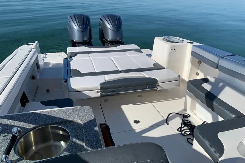 Slide: The Image of 2021 Robalo R317 Dual Console boat interior with seating and twin outboard motors. - 3