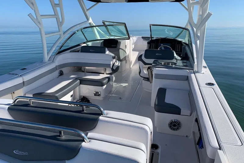 Slide: The Image of 2021 Robalo R317 Dual Console boat interior with seating and helm, on calm water. - 4