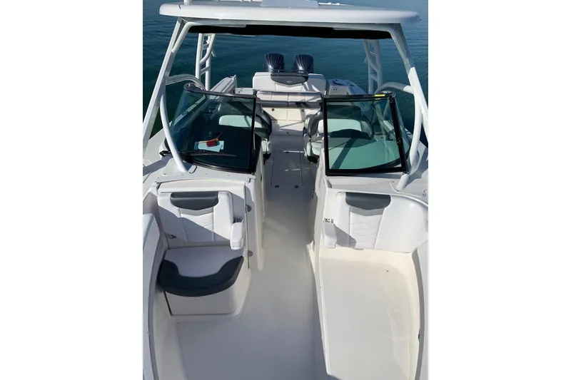 Slide: The Image of 2021 Robalo R317 Dual Console boat interior with seating and windshield, on calm water. - 5