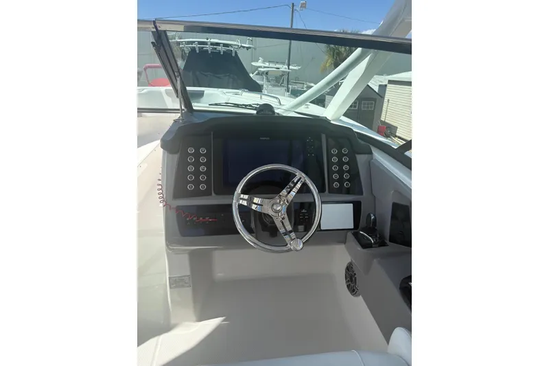 Slide: The Image of 2021 Robalo R317 Dual Console boat dashboard with steering wheel and control panel. - 7