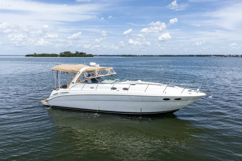 The Image of 2001 Sea Ray 380 Sundancer yacht cruising on a calm, scenic lake. - 1