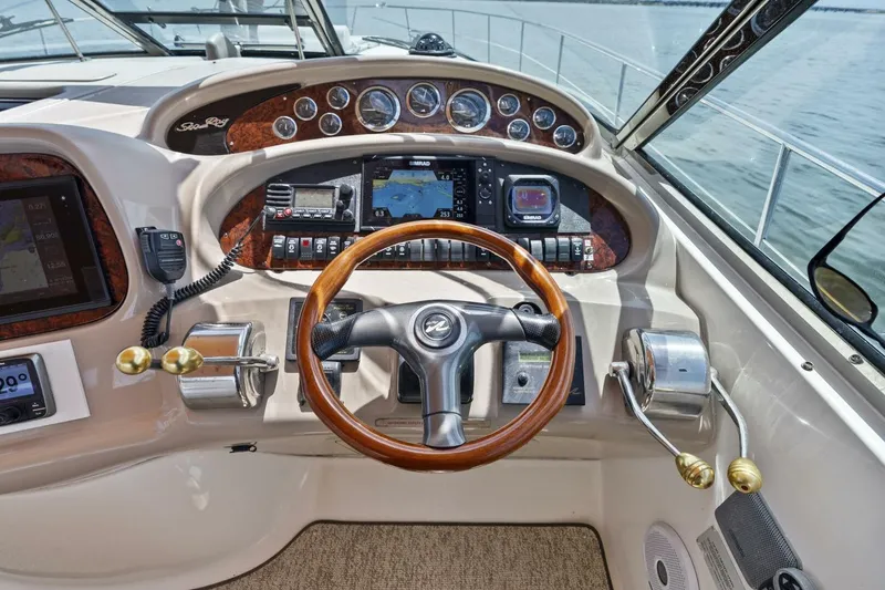 Slide: The Image of 2001 Sea Ray 380 Sundancer helm with wood steering wheel and navigation instruments. - 5