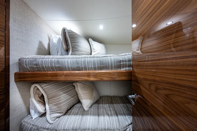 Slide: The Image of Bunk beds with striped bedding in a Viking yacht cabin, featuring wooden accents. - 51