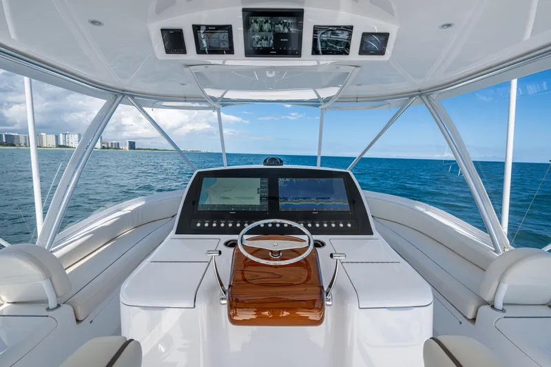 Slide: The Image of 2024 Viking 54 Convertible yacht helm with ocean view and advanced navigation system. - 8