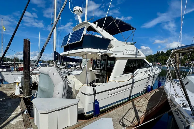 Slide: The Image of 1998 Bayliner 3388 Command Bridge Motoryacht docked at marina under blue sky. - 0
