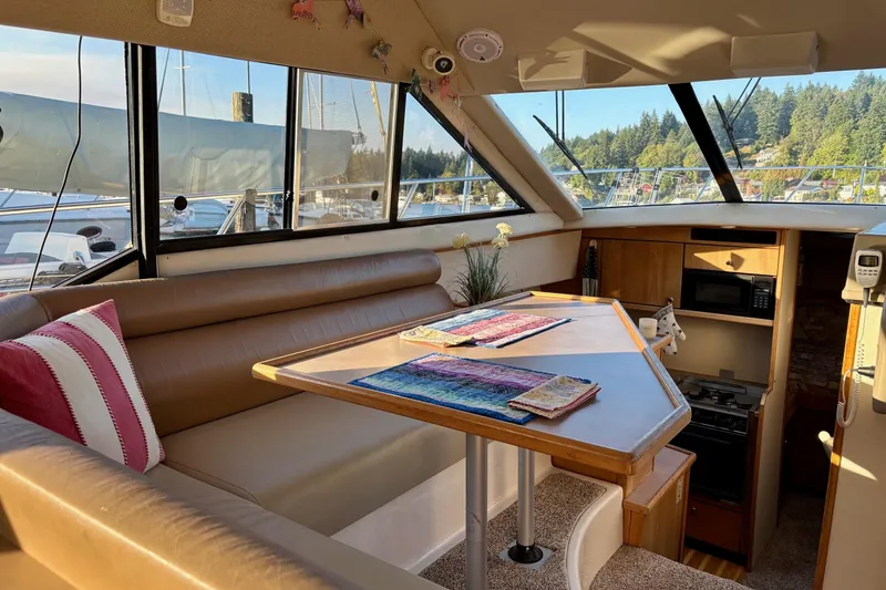 Slide: The Image of 1998 Bayliner 3388 Command Bridge Motoryacht interior with dining area and kitchen amenities. - 18