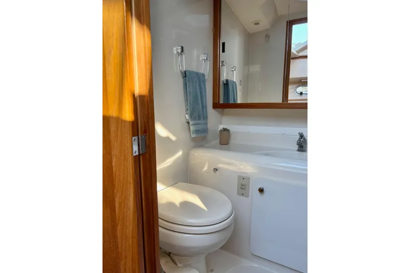 Slide: The Image of 1998 Bayliner 3388 Command Bridge Motoryacht bathroom with toilet, sink, and mirror. - 27