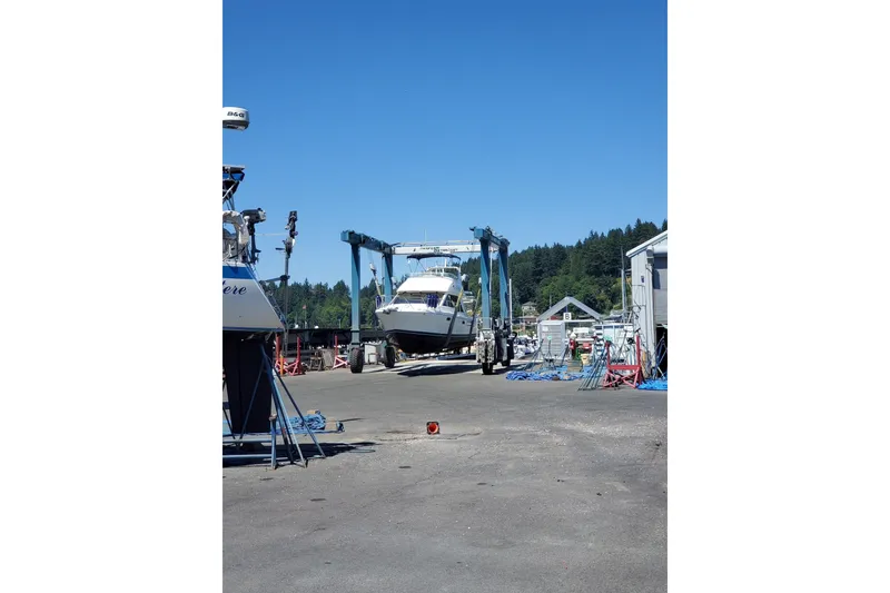 Slide: The Image of 1998 Bayliner 3388 Command Bridge Motoryacht being transported at a marina. - 3