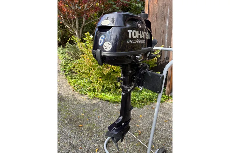 Slide: The Image of Tohatsu 6HP Four-Stroke outboard motor on stand, garden background. - 43