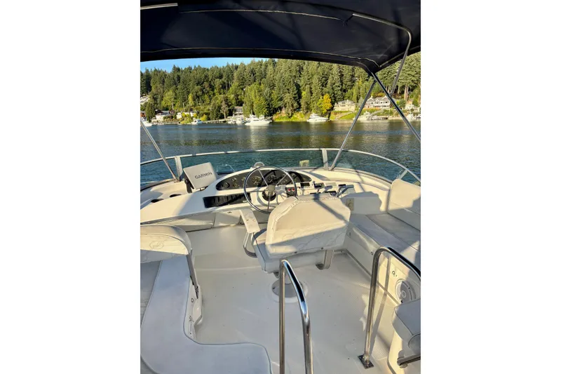 Slide: The Image of 1998 Bayliner 3388 Command Bridge Motoryacht interior with steering wheel, overlooking scenic waterway. - 9
