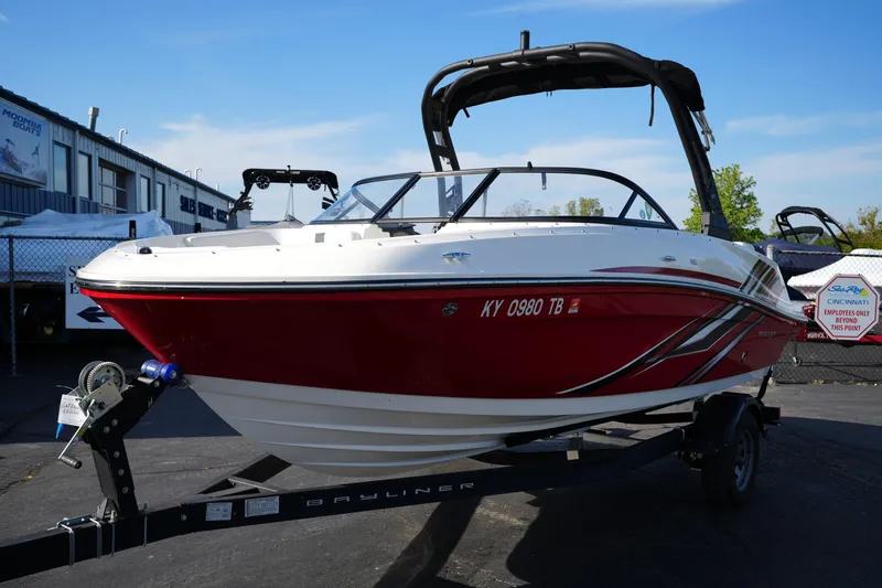 The Image of 2023 Bayliner VR5 Bowrider I/O boat on trailer, red and white design, outdoor display. - 1