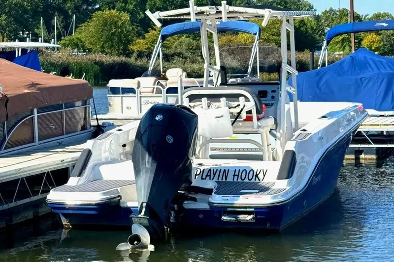 Slide: The Image of 2023 Bayliner Trophy T22CC boat docked, featuring "Playin Hooky" on the stern. - 1