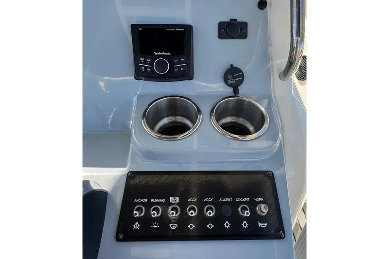 Slide: The Image of 2023 Bayliner Trophy T22CC dashboard with controls, cup holders, and audio system. - 18