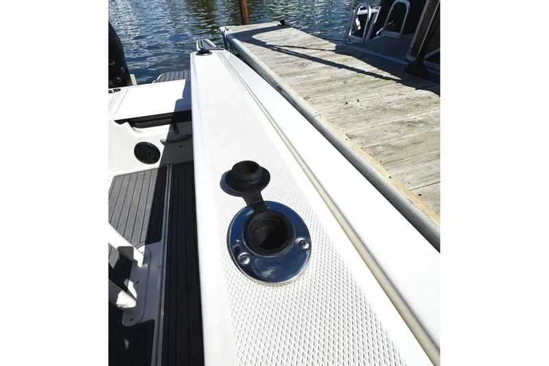 Slide: The Image of 2023 Bayliner Trophy T22CC boat detail near dock, showcasing deck and fittings. - 22