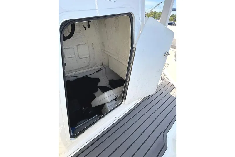 Slide: The Image of 2023 Bayliner Trophy T22CC interior storage compartment with open door on deck. - 25