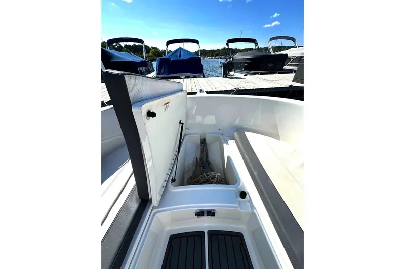 Slide: The Image of 2023 Bayliner Trophy T22CC boat with open storage compartment at dock. - 29