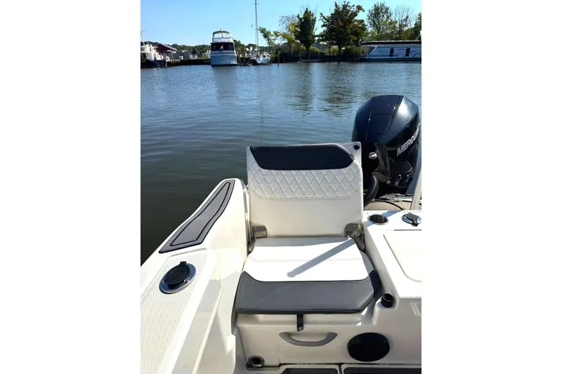 Slide: The Image of 2023 Bayliner Trophy T22CC boat with seating and Mercury outboard motor in a marina. - 34