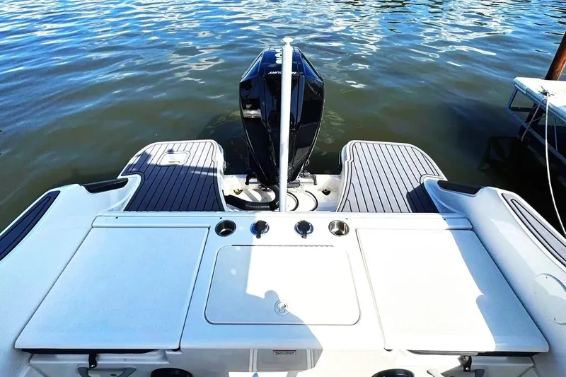 Slide: The Image of 2023 Bayliner Trophy T22CC boat stern with motor on calm water. - 4