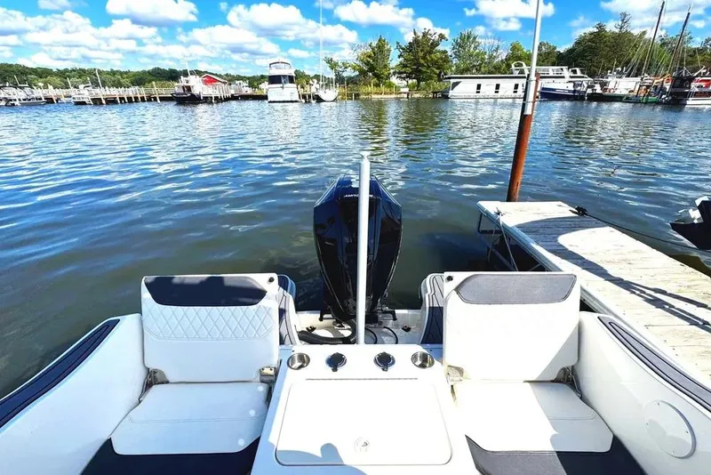 Slide: The Image of 2023 Bayliner Trophy T22CC boat docked at a marina with scenic water view. - 5