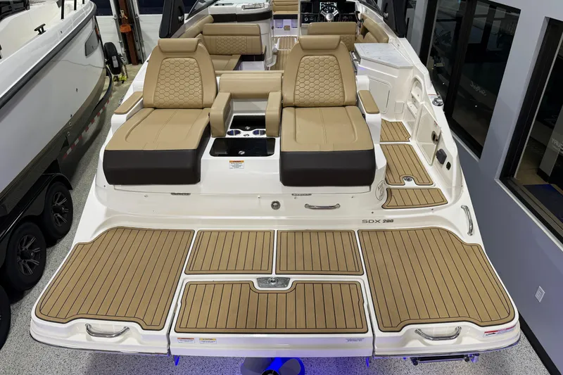 Slide: The Image of 2023 Sea Ray SDX 290 boat interior with tan seating and teak-style flooring. - 11
