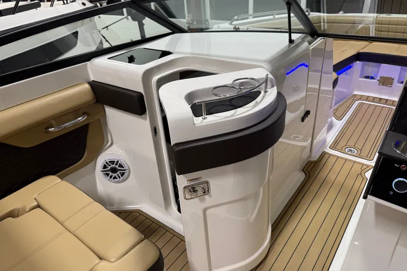 Slide: The Image of 2023 Sea Ray SDX 290 interior with tan seating, cup holders, and teak-style flooring. - 16