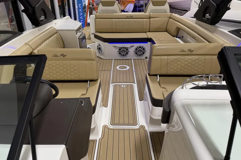 Slide: The Image of 2023 Sea Ray SDX 290 boat interior with tan seating and wood-style flooring. - 25