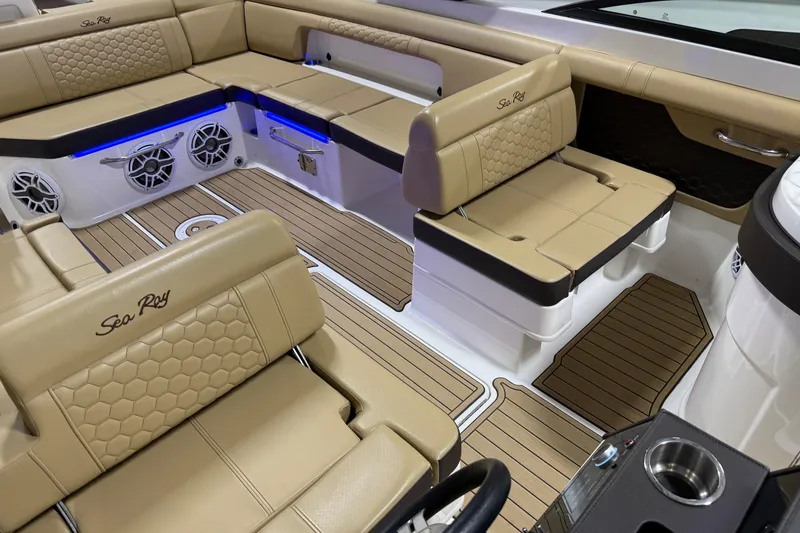 Slide: The Image of 2023 Sea Ray SDX 290 interior with tan seating, blue LED lights, and wood-style flooring. - 28