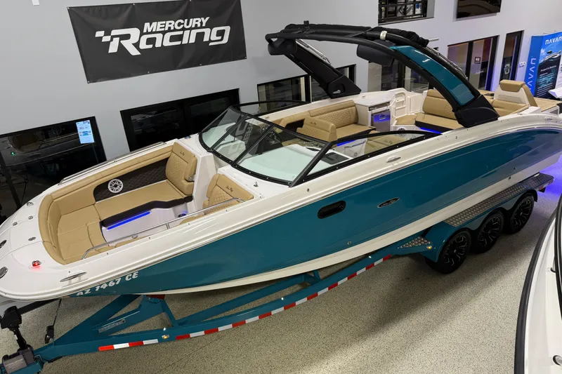 Slide: The Image of 2023 Sea Ray SDX 290 boat on trailer, displayed indoors with Mercury Racing banner. - 5