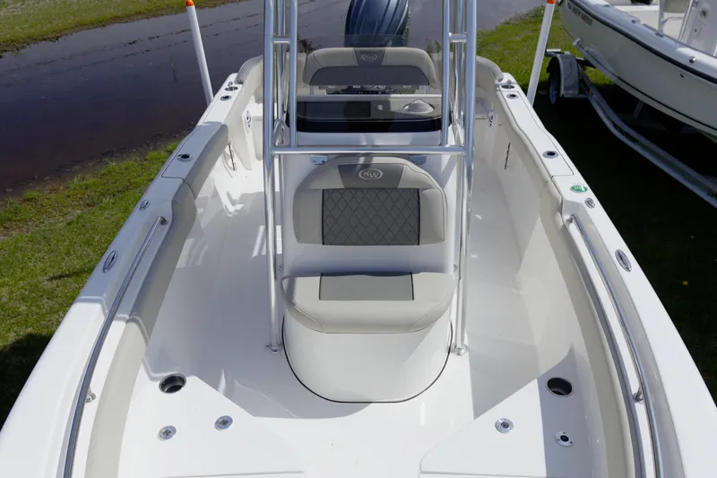Slide: The Image of 2026 Key West 203 FS boat interior with seating and console, displayed outdoors. - 24