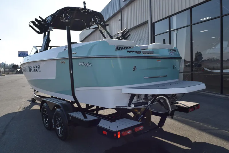 Slide: The Image of 2025 Moomba Mojo boat on trailer, parked near a building, rear view. - 4
