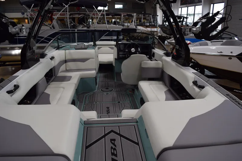 Slide: The Image of 2025 Moomba Mojo boat interior with spacious seating and modern design in a showroom. - 6