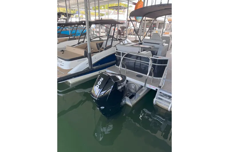 Slide: The Image of 2023 Godfrey SWEETWATER 2486 DT pontoon boat docked with Mercury outboard motor. - 5