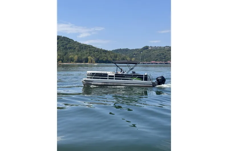 Slide: The Image of 2023 Godfrey SWEETWATER 2486 DT pontoon boat cruising on a scenic lake. - 6