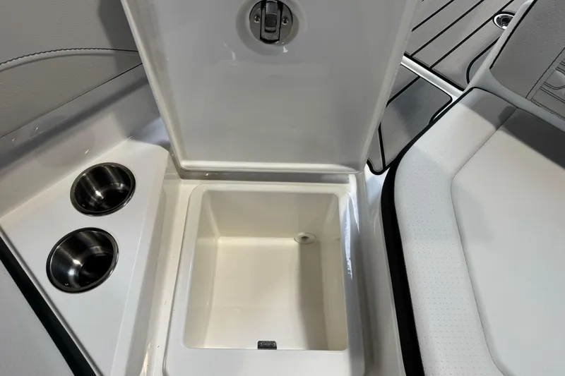 Slide: The Image of Open storage compartment on 2026 Sea Ray SPX 210 boat with cup holders. - 21
