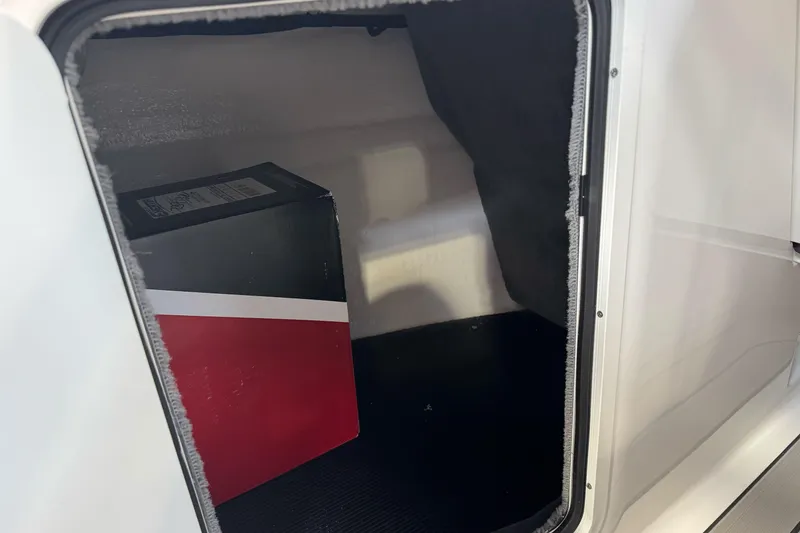 Slide: The Image of Storage compartment of 2026 Sea Ray SPX 210 boat with a red and black box inside. - 26
