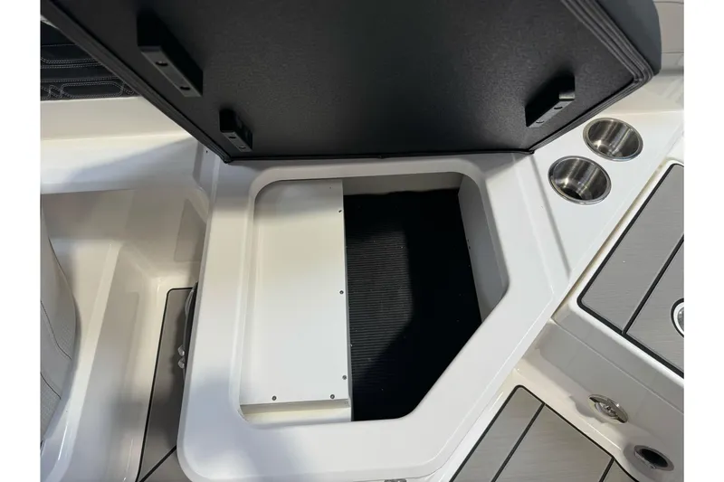 Slide: The Image of 2026 Sea Ray SPX 210 boat storage compartment with cup holders and sleek design. - 36
