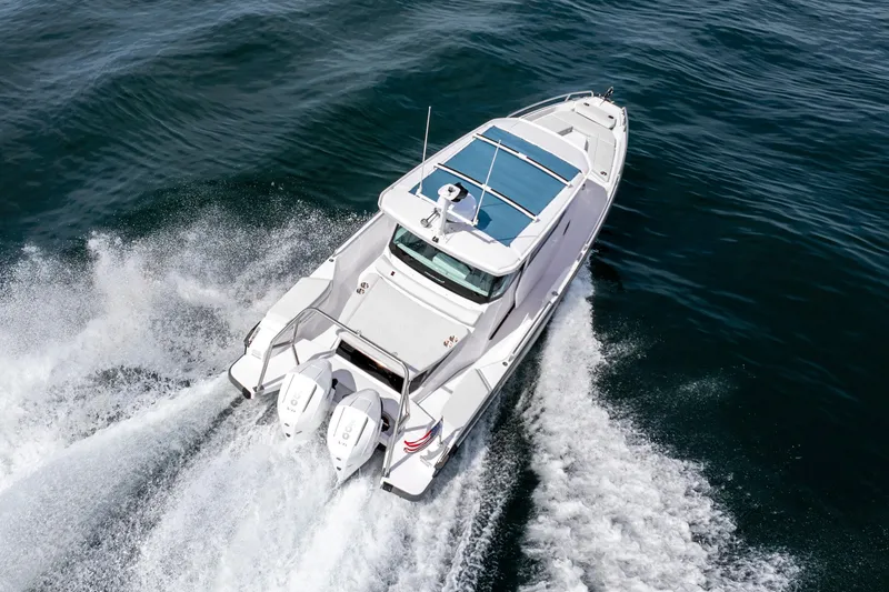 Slide: The Image of 2026 Axopar 29 XC Cross Cabin cruising on open water, showcasing sleek design and powerful engines. - 13