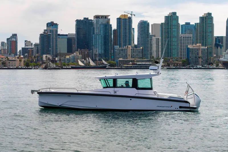 Slide: The Image of 2026 Axopar 29 XC Cross Cabin boat cruising near city skyline. - 15