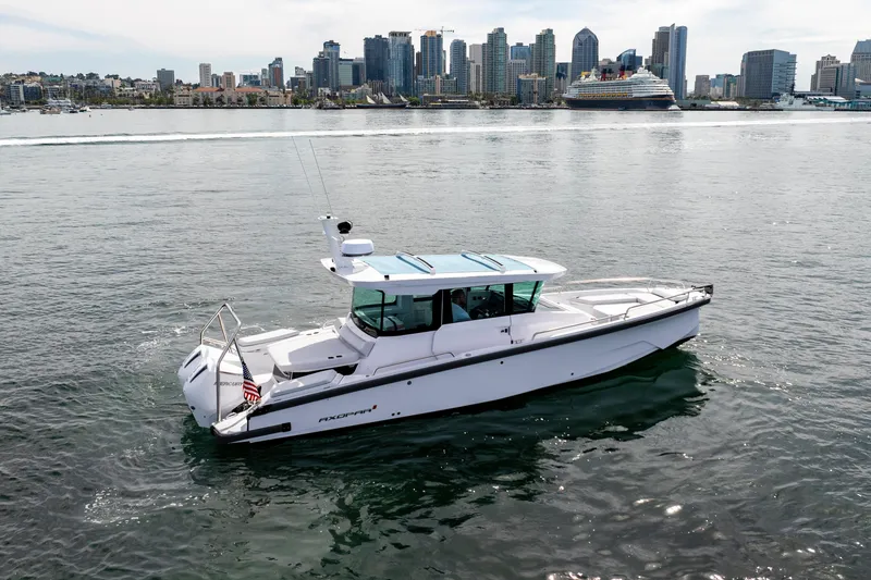 Slide: The Image of 2026 Axopar 29 XC Cross Cabin boat cruising near city skyline. - 17