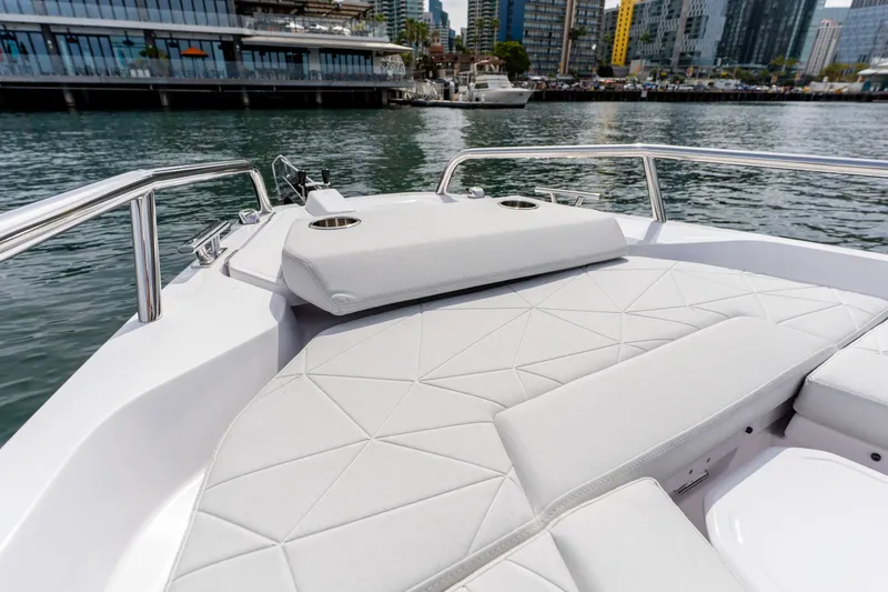Slide: The Image of 2026 Axopar 29 XC Cross Cabin boat with sleek white seating, docked in urban marina. - 32