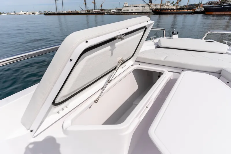 Slide: The Image of 2026 Axopar 29 XC Cross Cabin boat with open storage compartment, docked in a marina. - 34