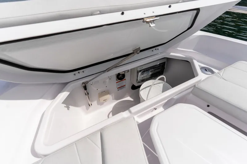 Slide: The Image of Storage compartment in 2026 Axopar 29 XC Cross Cabin boat, featuring white interior and seating. - 35