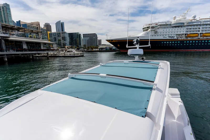 Slide: The Image of 2026 Axopar 29 XC Cross Cabin in urban harbor with cruise ship backdrop. - 36