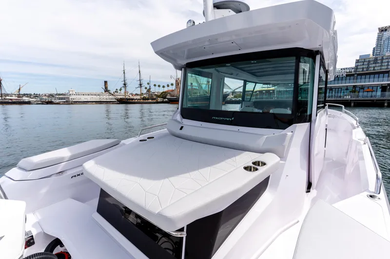 Slide: The Image of 2026 Axopar 29 XC Cross Cabin boat docked near historic ships and waterfront buildings. - 38