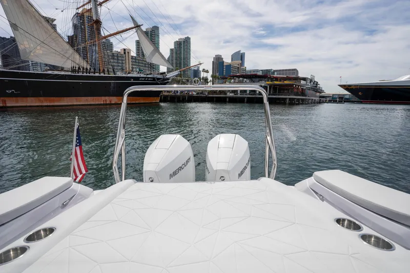 Slide: The Image of 2026 Axopar 29 XC Cross Cabin boat with Mercury engines, docked near a historic ship. - 40