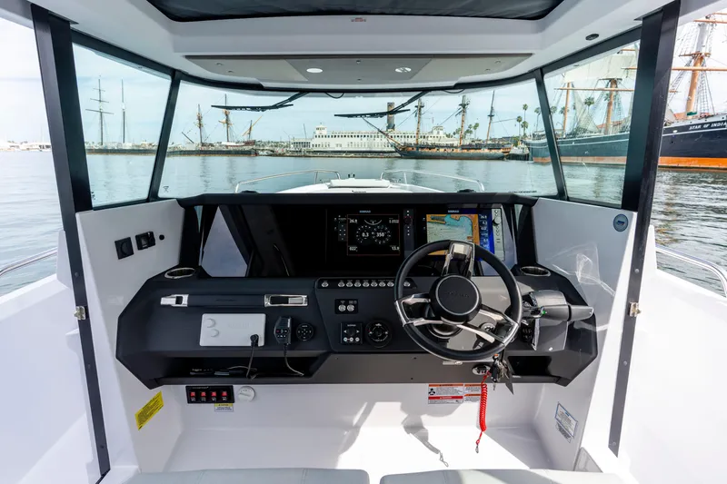 Slide: The Image of 2026 Axopar 29 XC Cross Cabin helm with modern navigation system and waterfront view. - 43